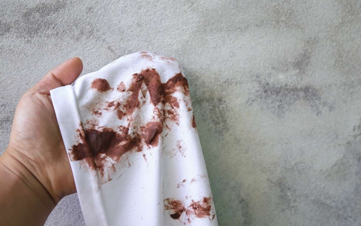 Image showing a hand holding a white cloth stained with chocolates