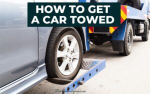 Image of car front right wheel in towing contraption attached to tow truck with text overlay that reads "How to get a car towed".