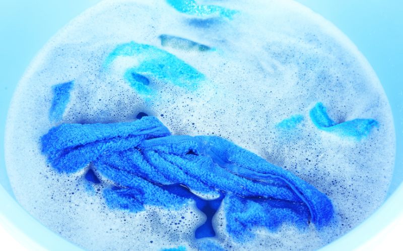 Blue cloth in soaked in basin with soap
