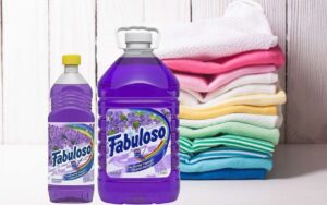 Purple colored Fabuloso in containers beside folded laundry