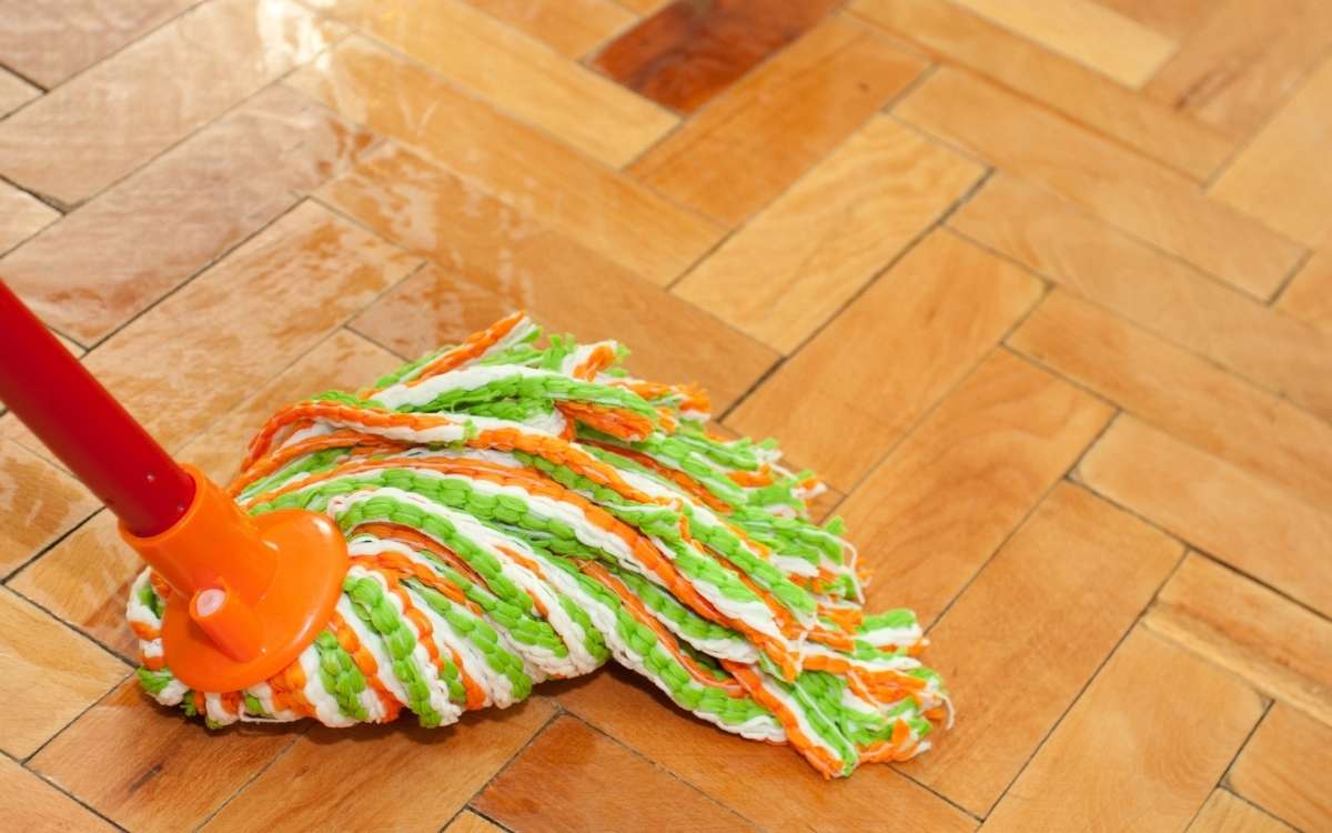 Photo of a colorful mop against the wooden floor as one of the baking soda uses