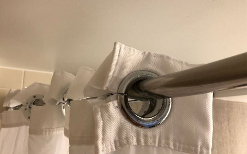 The top part of a shower curtain on metal rod