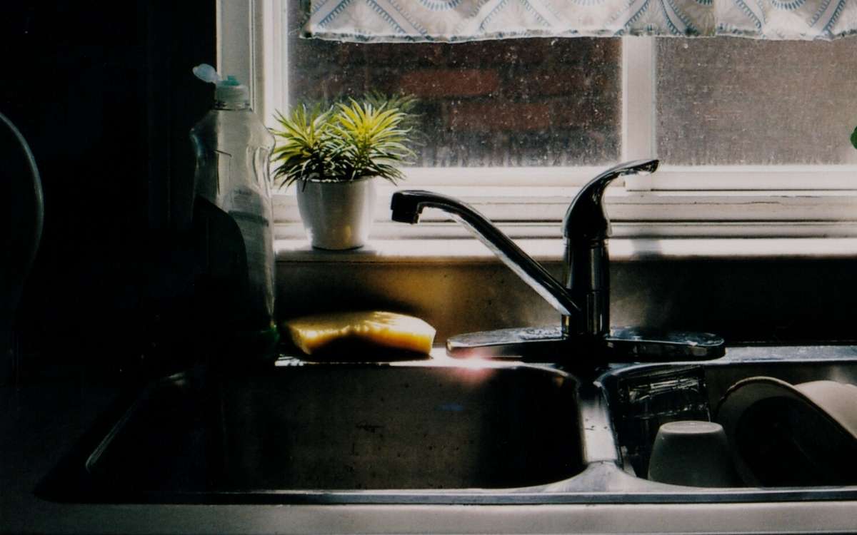 Photo of empty sink and a sink with dishes by a window left for overnight.