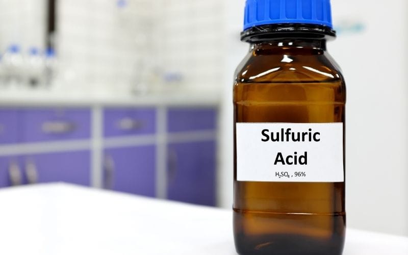 Image of a brown colored jar with blue cap labeled Sulfuric Acid