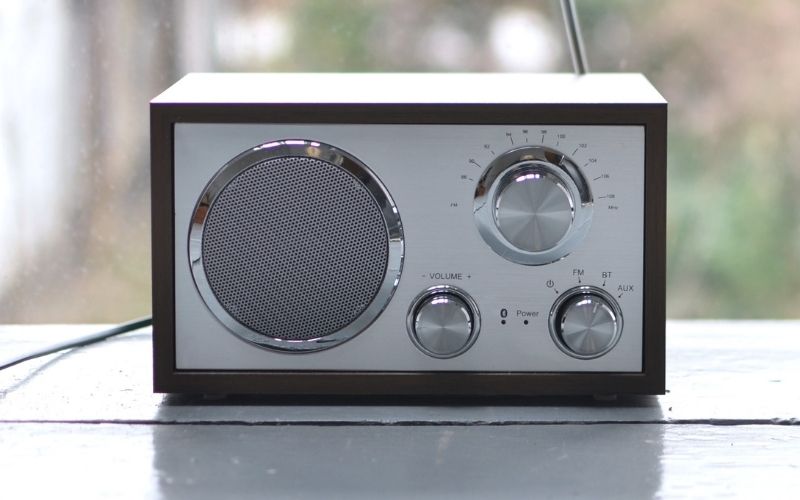 Photo of a small radio on a grey colored table that may keep racoons away from deck