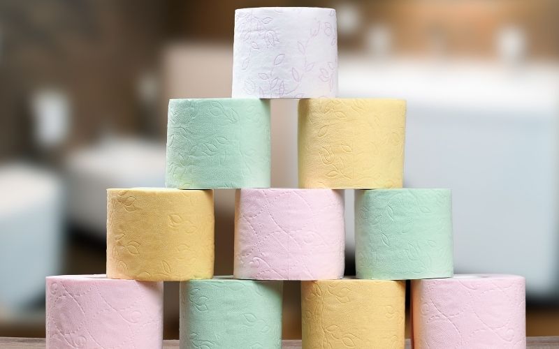Phot of several toilet paper rolls in white, yellow, green and pink colors