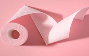 Photo of a pink toilet paper in pink background