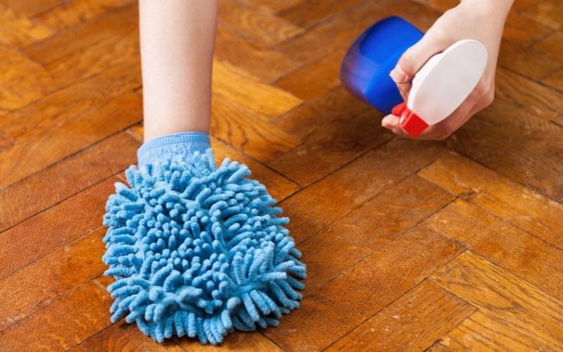 Photo showing wooden floor being cleaned using hand mop