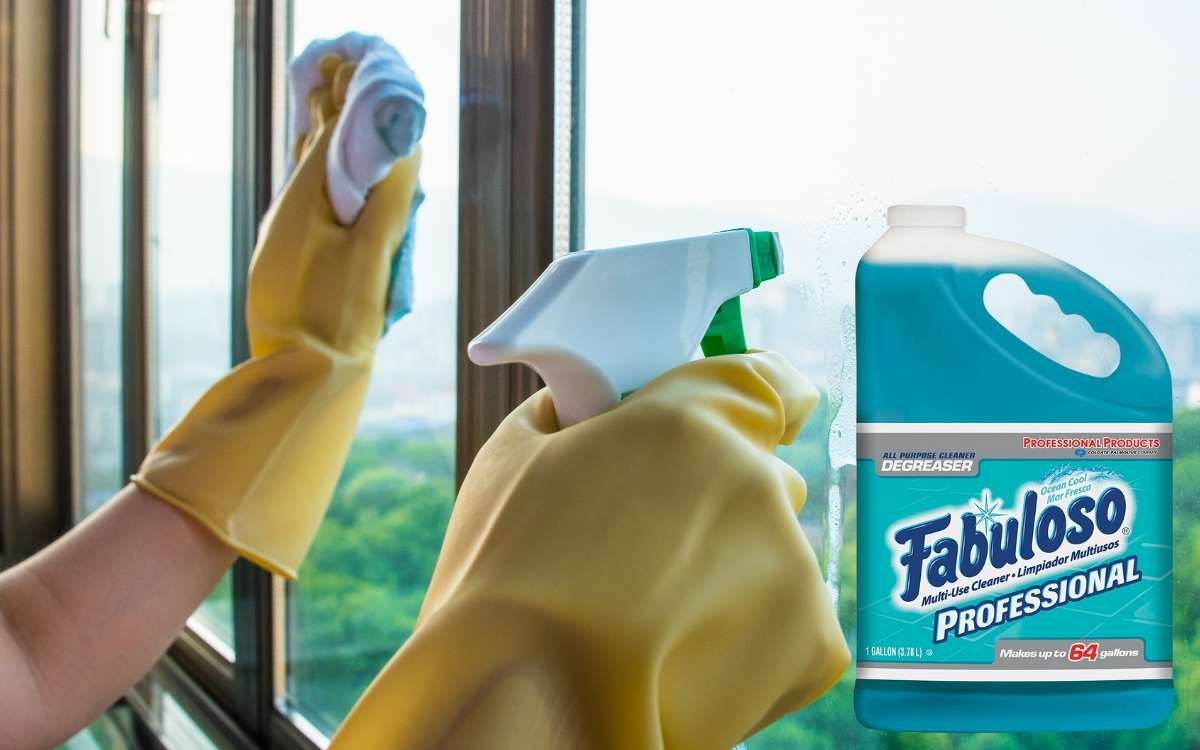 Image showing a gallon of fabuloso and a person holding a spray and cloth while cleaning the windows