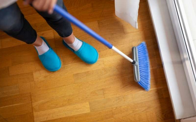 Photo of a person sweeping the floor