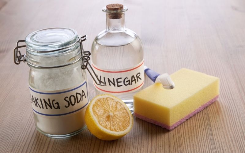 Image showing a bottle of vinegar, a jar of baking soda, a slice of lemon and a sponge