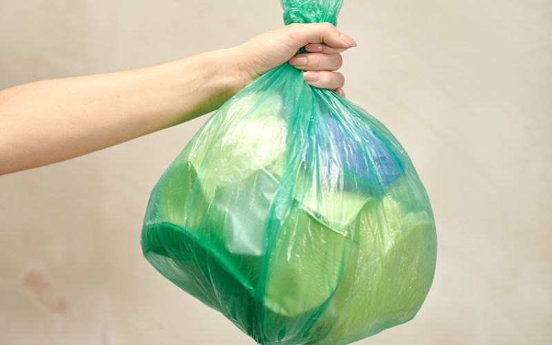 Photo showing a hand holding a plastic bag with items inside