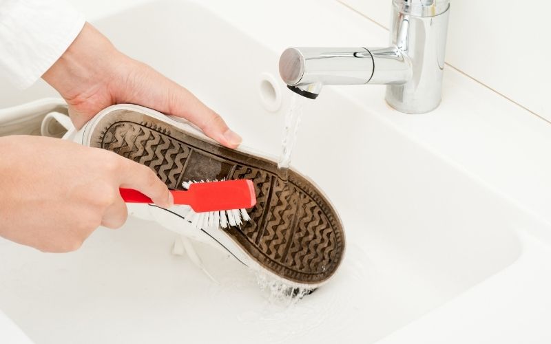 Photo of the underside of a shoe being brushed