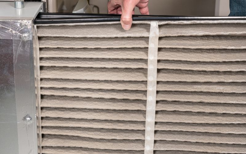Photo showing a dirty filter held by a hand