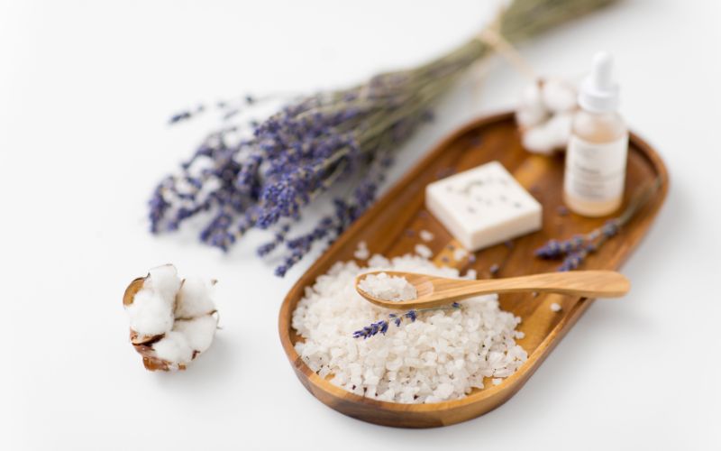 Phto of white granules with wooden spoon, and cut lavender