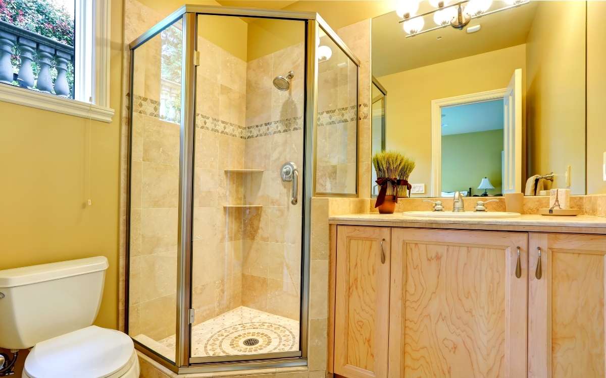 Photo showing a hotel bathroom with a shower that has clean glass door