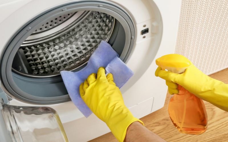 Photo showing a pair of hands cleaning the dryer