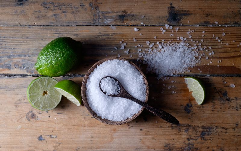 Photo of slices of lime, a small bowl of salt and a teaspoon