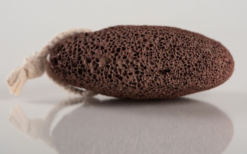 A brown pumice stone with tie at the end with reflection
